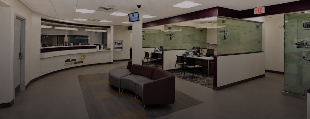 Lobby of an AllCom Credit Union branch with a reception desk, waiting area, and partitioned offices
