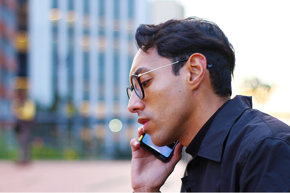 Man in glasses talking on a smartphone, potentially discussing financial security or scams