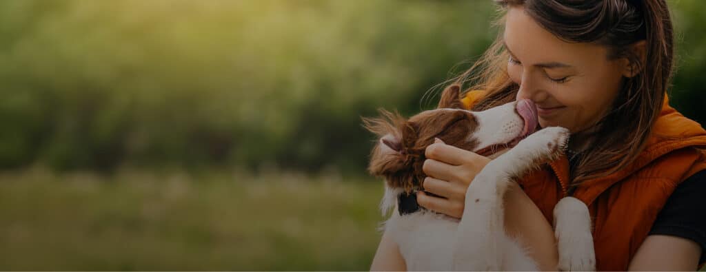 Woman smiling with eyes closed as a dog licks her face