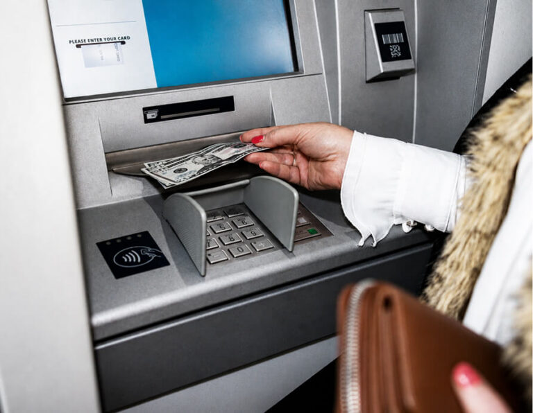 Hand withdrawing cash from an ATM