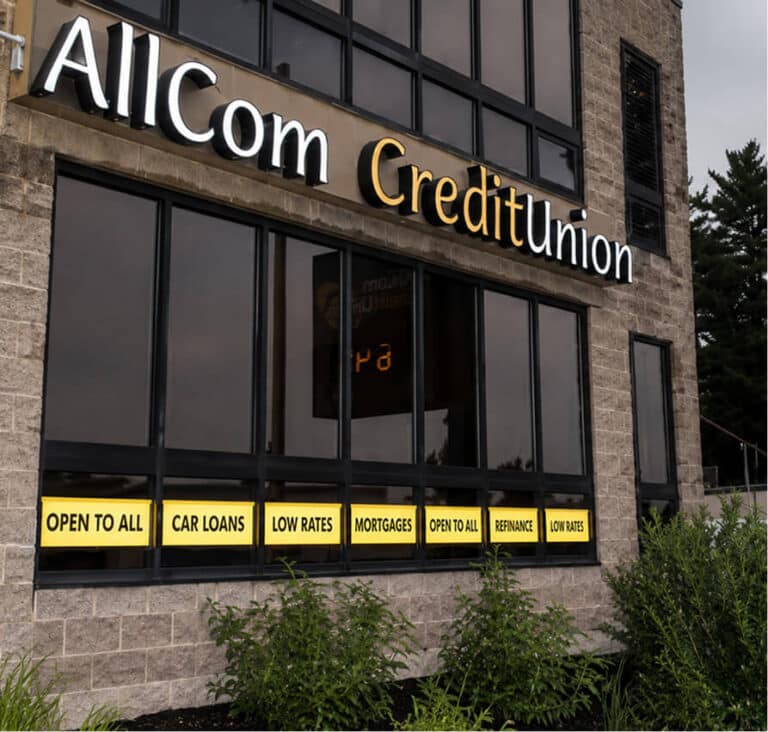 AllCom Credit Union building with signs for "Open to all", "Car Loans", "Low Rates", "Mortgages", "Refinance"