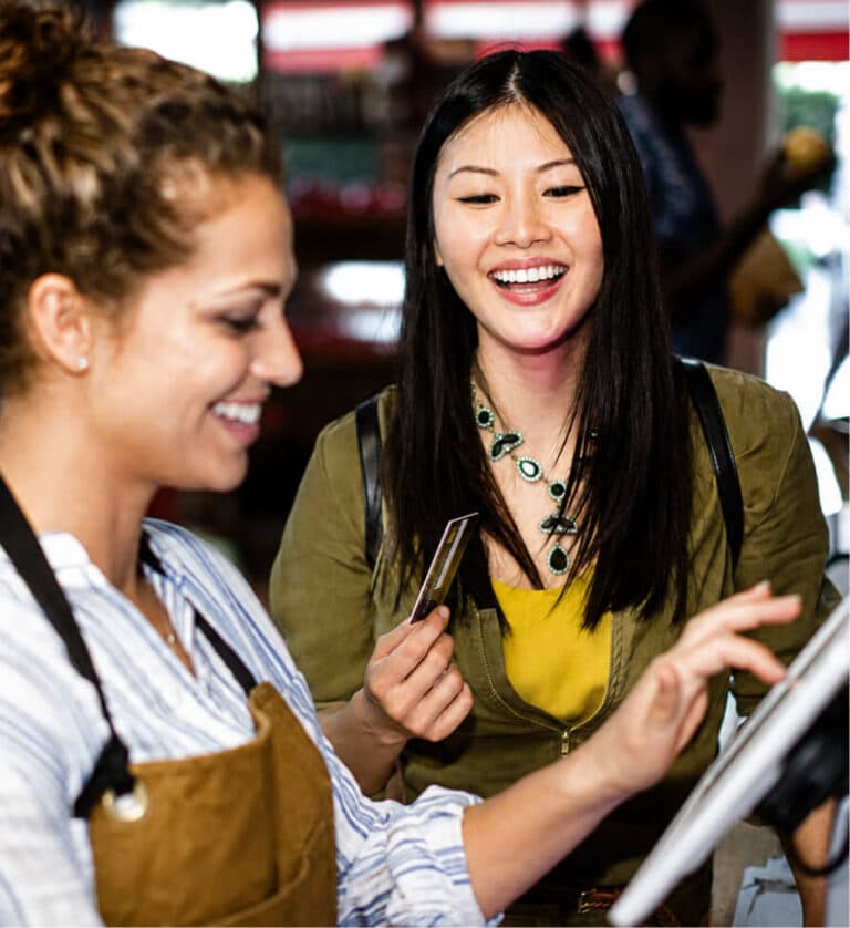 Customer smiles while holding a credit card at checkout