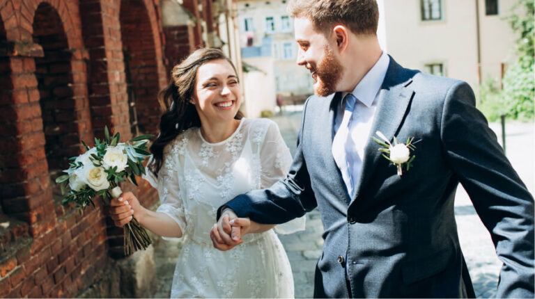 Happy bride and groom holding hands and smiling